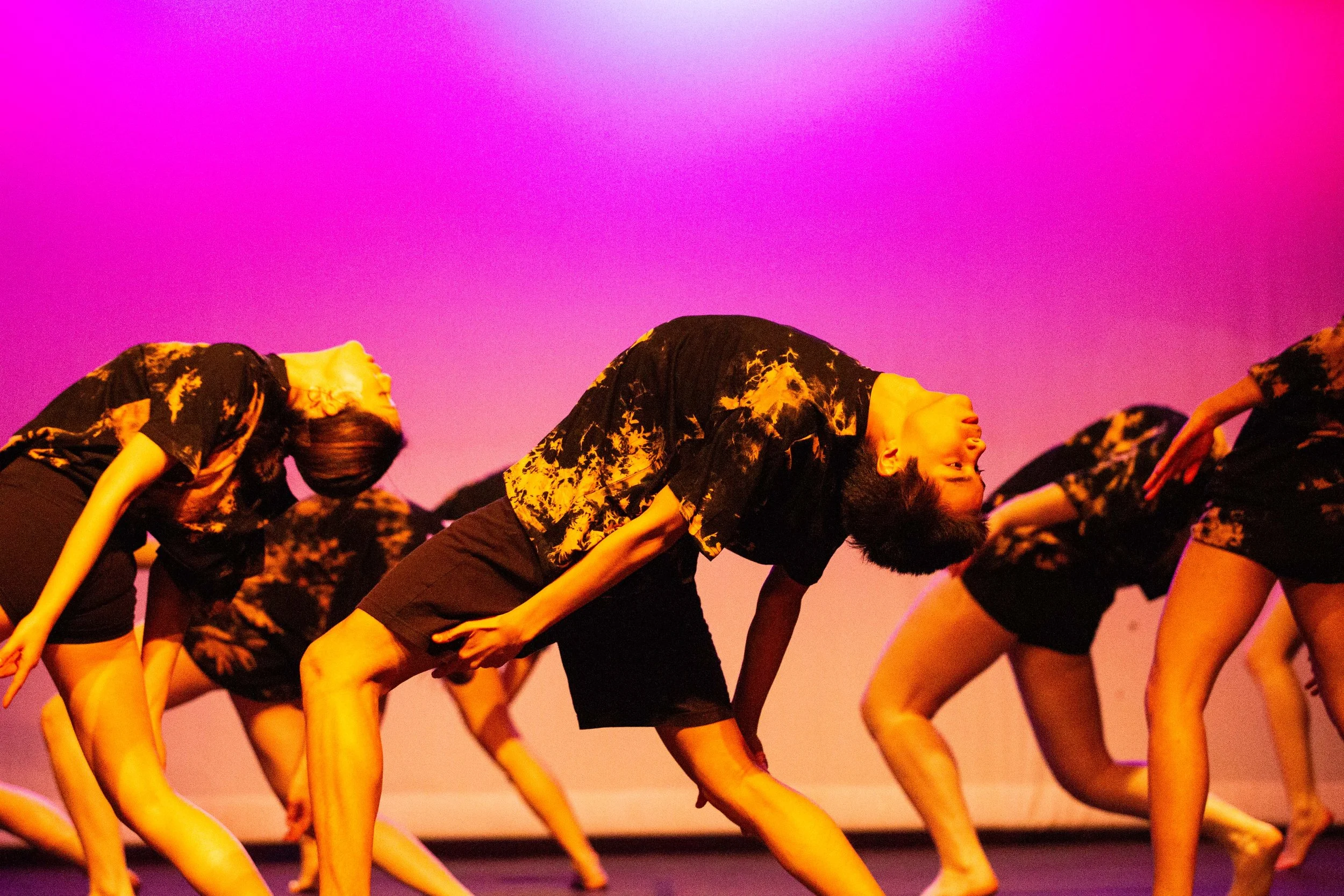 Dancers rehearsing contemporary jazz technique in the studio.
