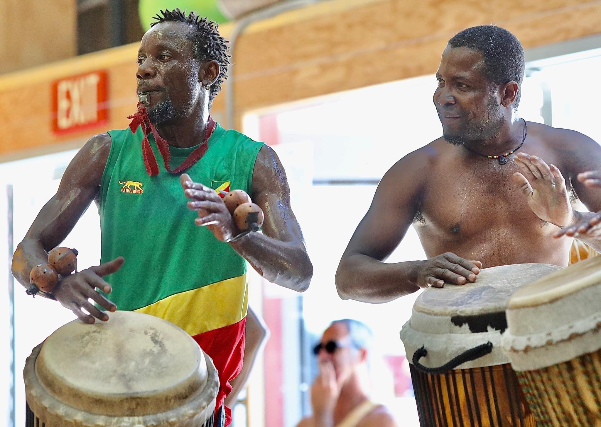 Two percussionists playing hand drums together in the studio.