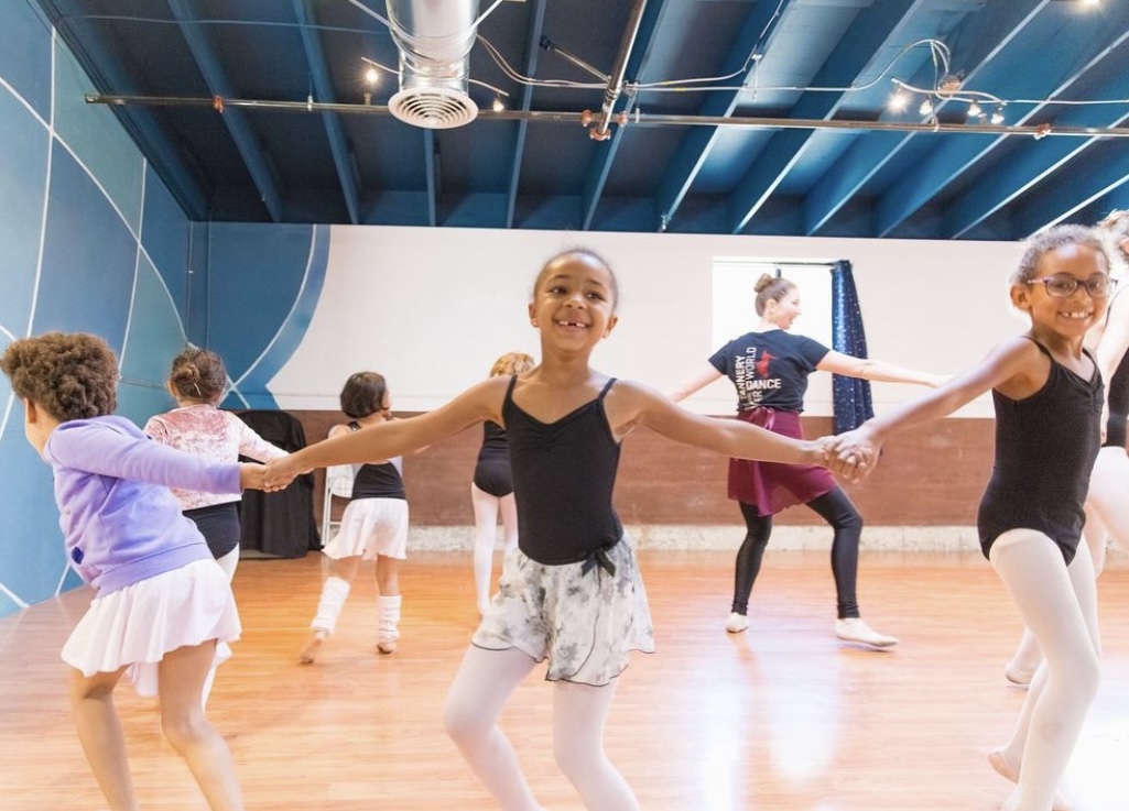 Young dancers practice ballet together in the studio.