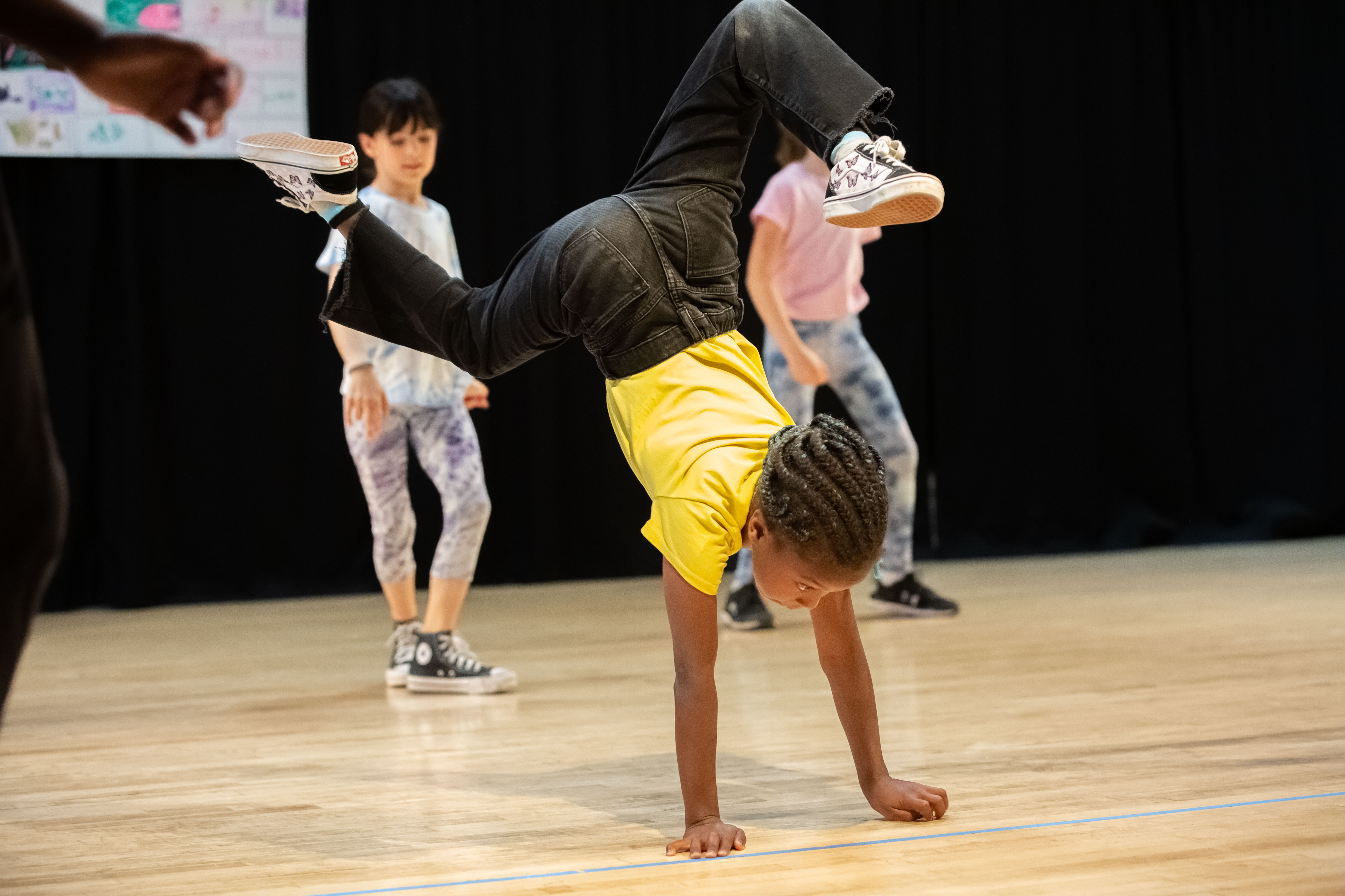 A young dancer practices a handstand in class.