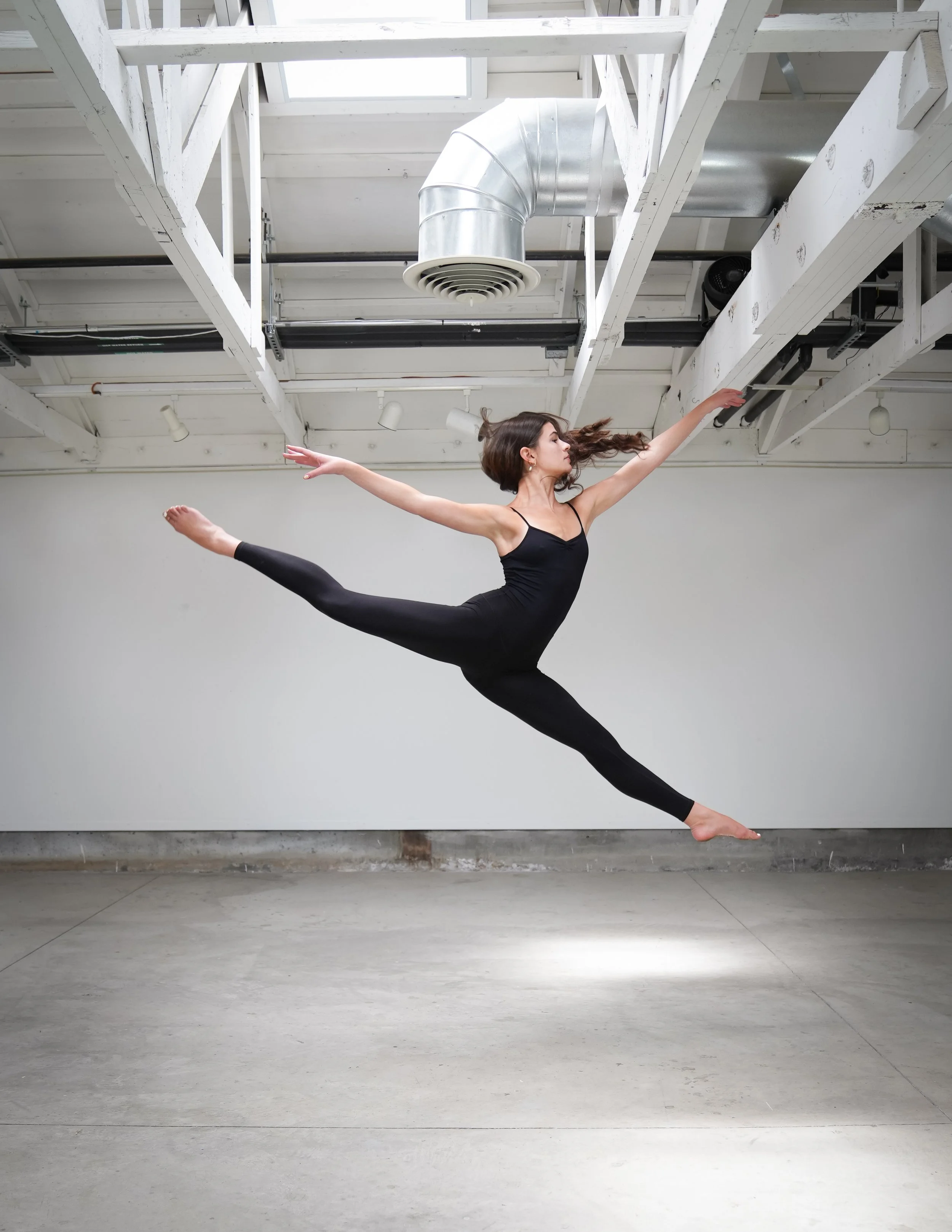 A TWDCC Ballet Company dancer captured mid-jump in the studio.