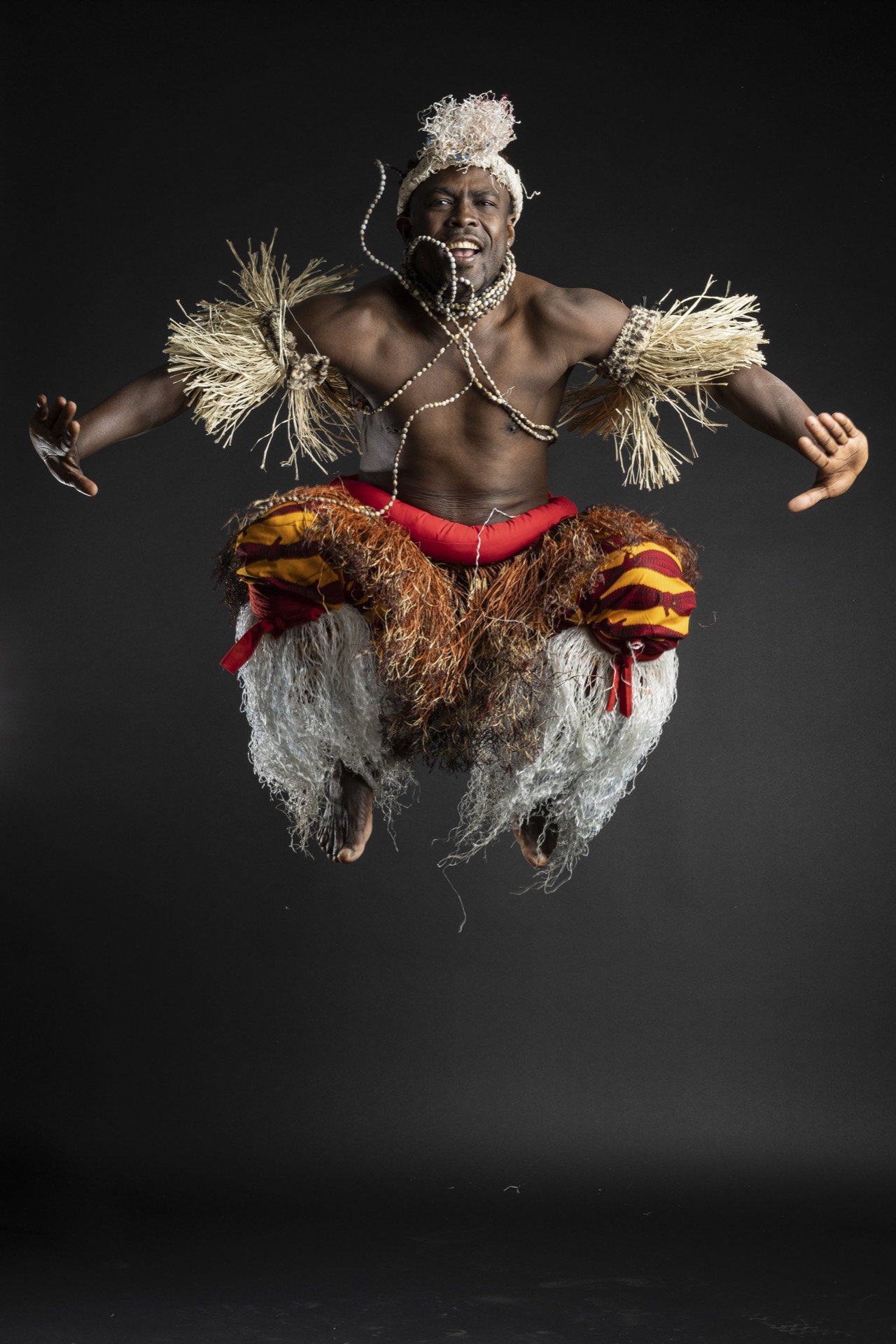 A TWDCC dancer in traditional dress, mid-jump.